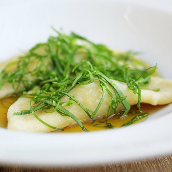 Gnocchi mit frischen Kräutern und Butter in weißer Schüssel.
