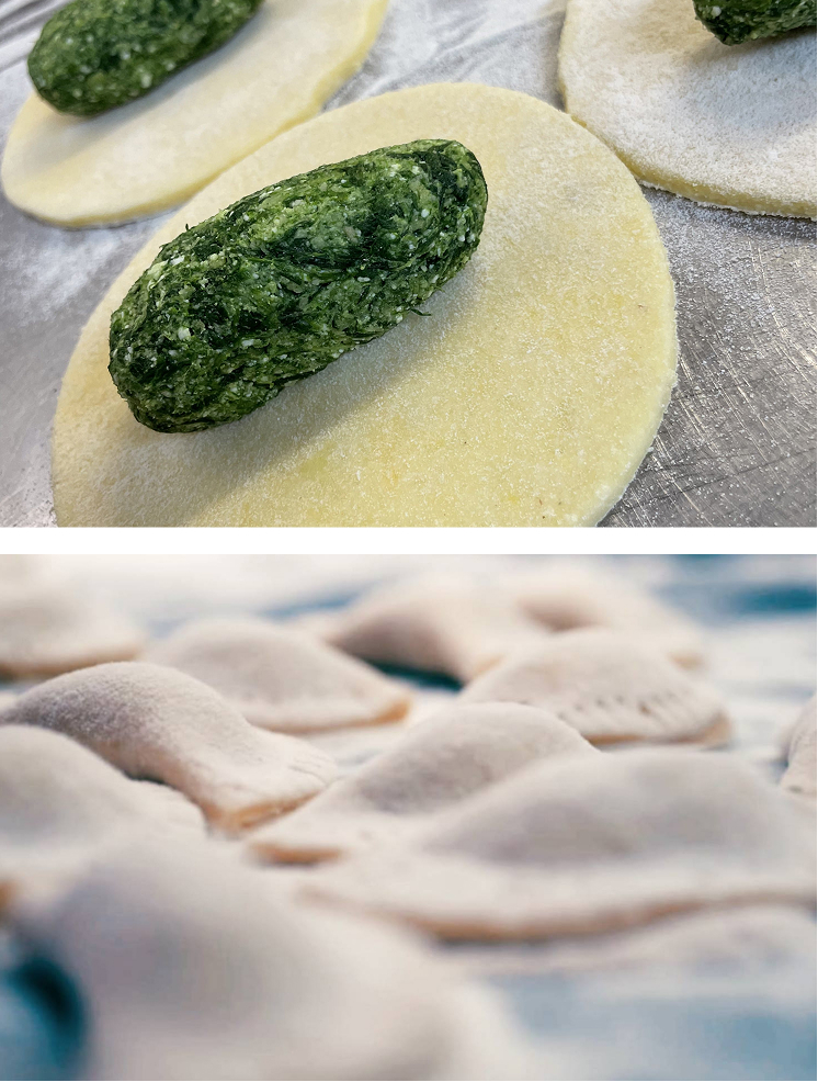Hefeteig mit Spinatfüllung und ungebackene Ravioli auf einer Arbeitsfläche.
