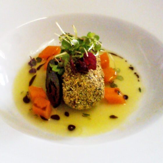 Gebackener Fisch mit Gemüse und Kräutern auf weißem Teller.